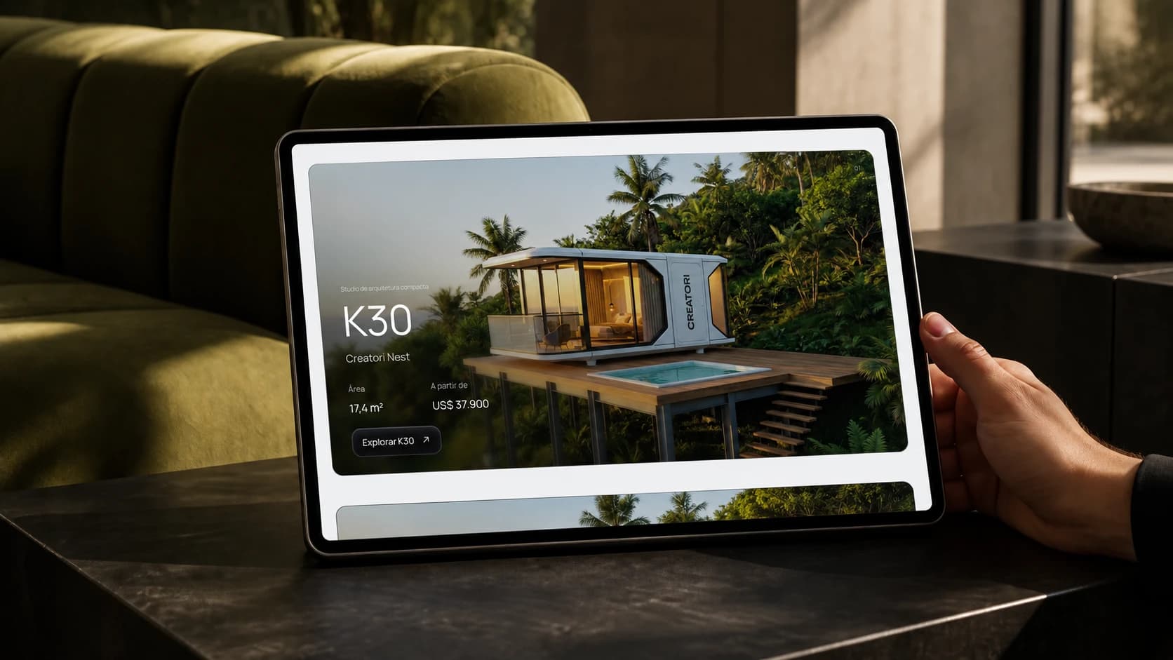 Website Creatori em um tablet apoiado sobre uma mesa, com sofá verde ao fundo