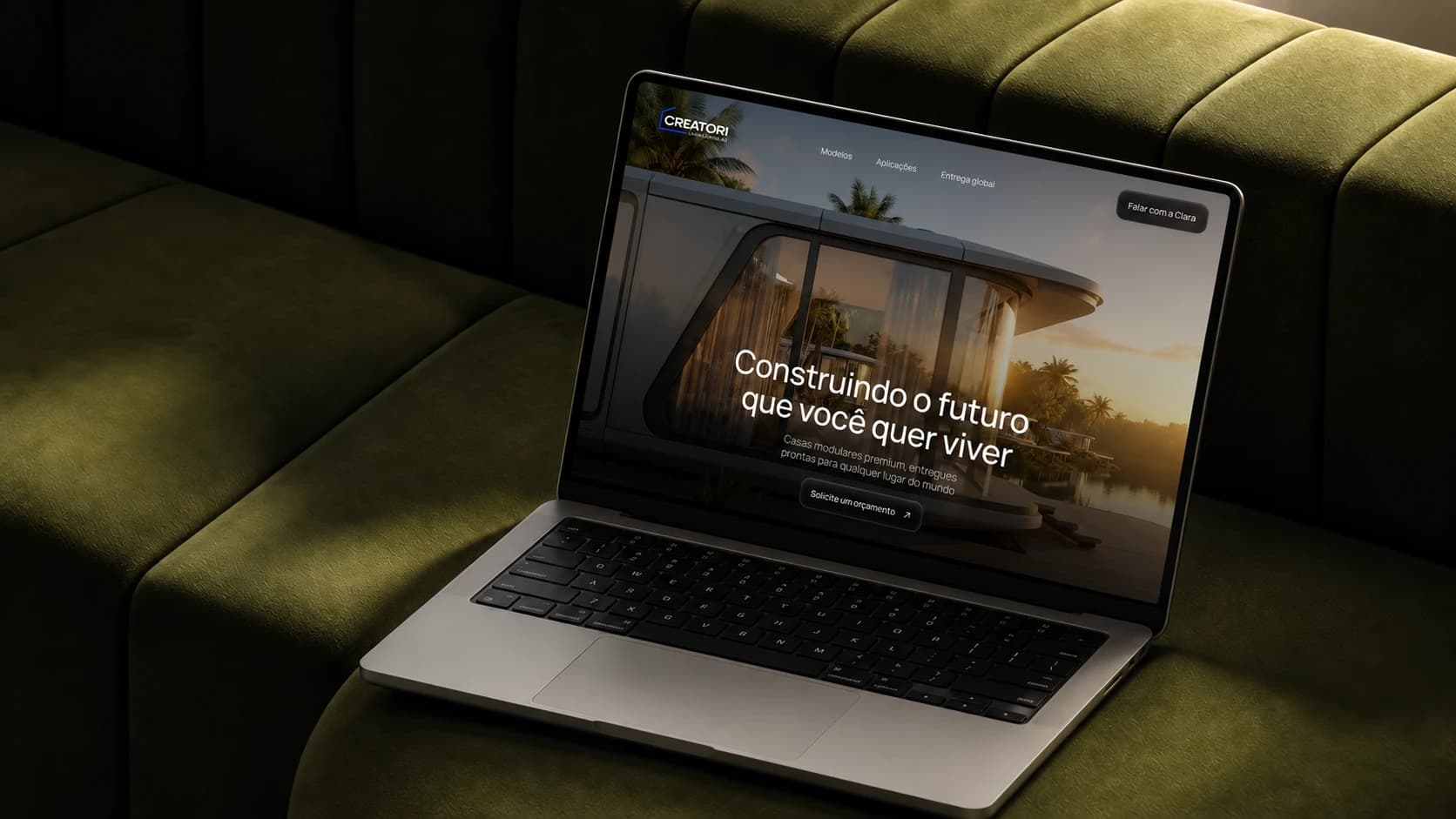 Website Creatori em um MacBook sobre um sofá verde